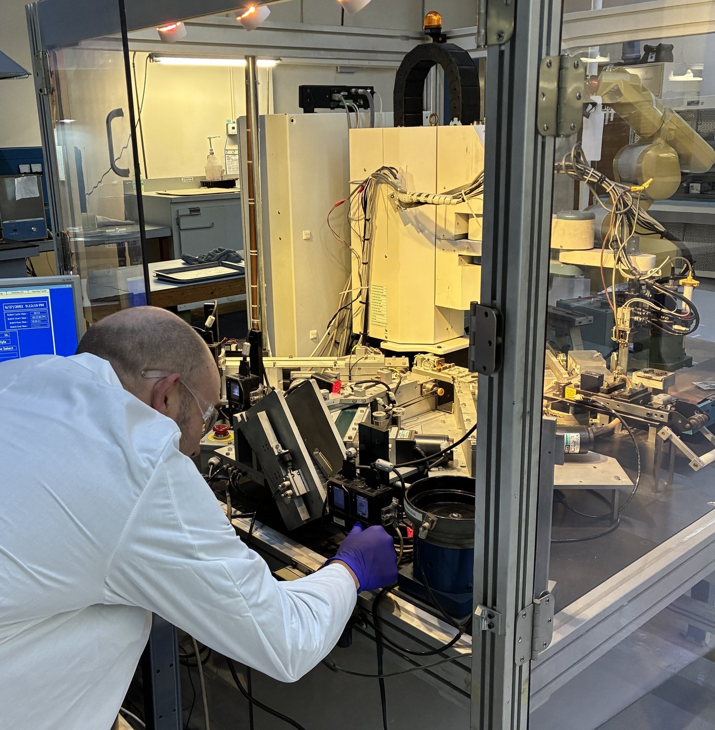 Technician operating precision automated test equipment at Component General's Odessa, Florida facility